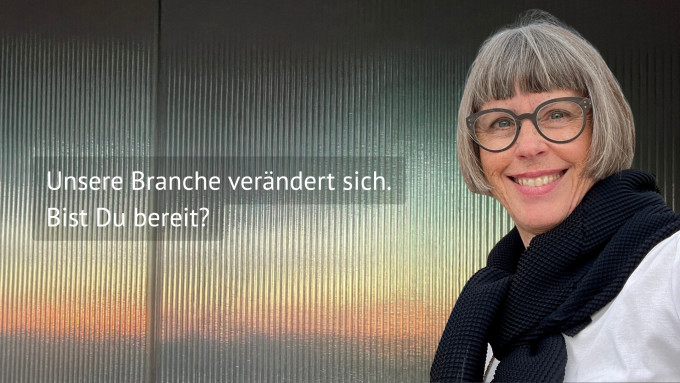 Karin Stehr vor einer metallischen Wand mit Sonnenaufgang Reflektion und einem Text: Unsere Branche verändert sich. Bist Du bereit?!