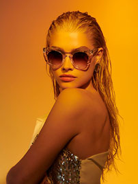 Sonnenbrille von Thierry Lasry, Portrait einer blonden jungen Frau mit Glitzertop und einer semitransparten ausserwöhnlichen Sonnenbrille von Thierry Lasry