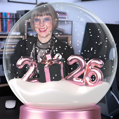 Karin Stehr am Schreibtisch hinter einer weihnachtlichen Glaskugel mit einem großen 2026
